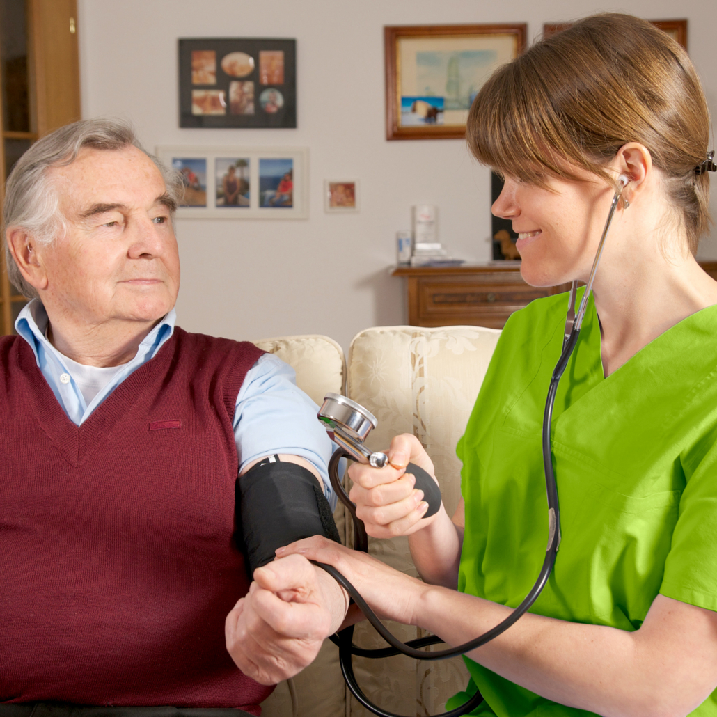 Pflegekraft misst Blutdruck bei Senior