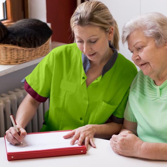 Altenpflegerin beim Hausbesuch einer Patientin